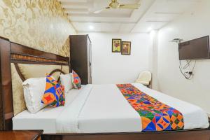 a hotel room with a bed and a tv at FabHotel The Villa in Kānpur