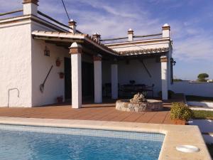 a house with a swimming pool and a patio at El Matorral Chalet in Vejer de la Frontera