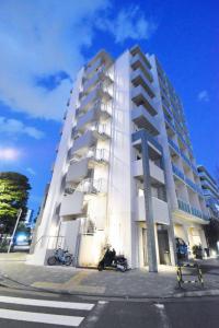 a white building with motorcycles parked in front of it at Regalo shibaura 801 in Tokyo