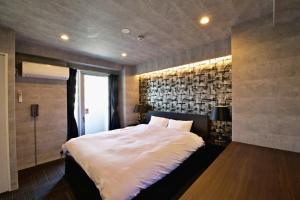 a bedroom with a large bed and a brick wall at Regalo shibaura 801 in Tokyo