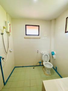 a bathroom with a toilet and a window at Ma Baan House by the sea in Cha Am Beach