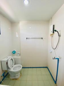 a bathroom with a toilet and a shower at Ma Baan House by the sea in Cha Am Beach