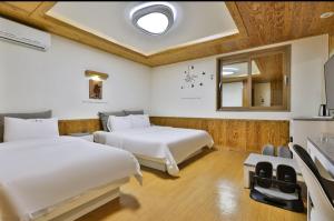 YangsanにあるTime Hotelのベッド2台と窓が備わるホテルルームです。