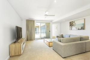 a living room with a couch and a flat screen tv at Cottesloe Beach Haven in Perth