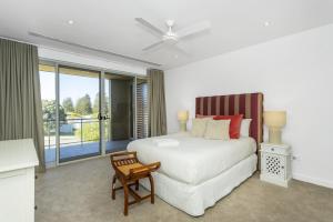 a bedroom with a bed and a chair and a window at Cottesloe Beach Haven in Perth