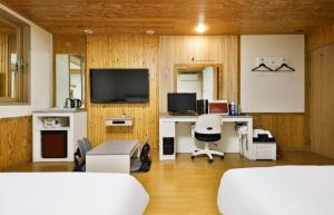 a room with two beds and a desk and a television at Time Hotel in Yangsan
