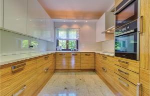 a large kitchen with wooden cabinets and a television at Gorgeous Home In Bribir With Outdoor Swimming Pool in Bribir