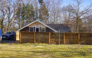 una pequeña casa con una valla de madera en un patio en Nice Home In Give With Wifi en Give