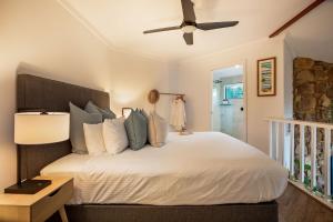 a bedroom with a white bed with a ceiling fan at The Lookout, Eagle Bay in Dunsborough