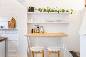 a kitchen with two stools and shelves with plants at The Lookout, Eagle Bay in Dunsborough +13 photos