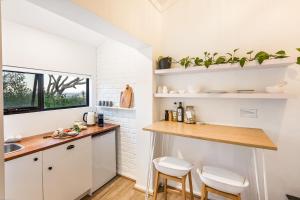 a kitchen with white cabinets and a counter with two stools at The Lookout, Eagle Bay in Dunsborough