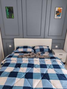 a blue and white plaid bed in a bedroom at Swiss Home Horizon Suite 2 in Sepang