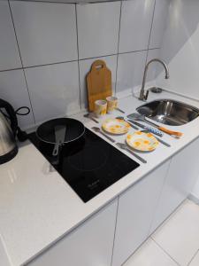 a kitchen counter with a stove and a sink at Swiss Home Horizon Suite 2 in Sepang