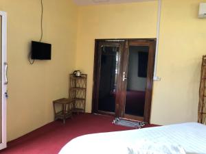 um quarto com uma cama e uma porta de vidro deslizante em Sofinny Motel 2 em Sihanoukville