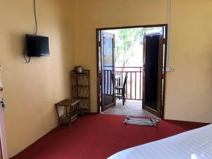 a bedroom with a door open to a balcony at Sofinny Motel 2 in Sihanoukville