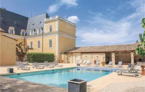 a swimming pool in front of a house with a building at Stunning Home In Pont Saint Esprit With Kitchen in Pont-Saint-Esprit