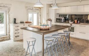 a kitchen with a large island with bar stools at Stunning Home In Pont Saint Esprit With Kitchen in Pont-Saint-Esprit