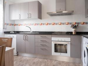 a kitchen with white cabinets and a sink at Villa Joan in Riumar