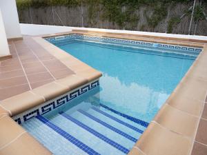 a swimming pool with blue water and tan seats at Villa Joan in Riumar