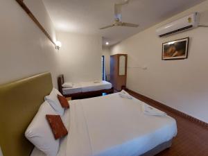 a hotel room with two beds in a room at THE TIGER PAW RESORT in Masinagudi