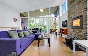 グレーノにある3 Bedroom Nice Home In Grenaaの紫色のソファとレンガの壁が備わるリビングルーム