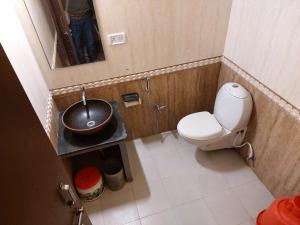 a small bathroom with a toilet and a sink at THE TIGER PAW RESORT in Masinagudi