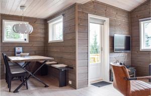 una camera con una parete in legno, un tavolo e una TV di Nice Home In Vrdal With House A Mountain View a Vrådal