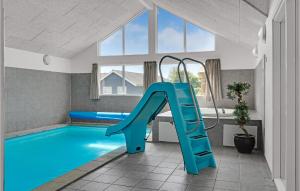a pool with a slide in a room with a swimming pool at Amazing Home In Sydals With Indoor Swimming Pool in Høruphav