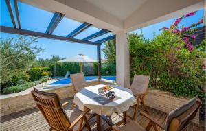 a patio with a table and chairs and a swimming pool at Nice Home In Liznjan With 4 Bedrooms, Wifi And Outdoor Swimming Pool in Ližnjan