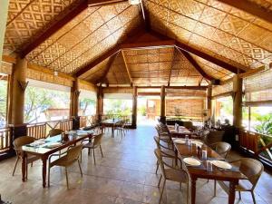 a restaurant with wooden tables and chairs in a room at Magic Island Dive Resort in Moalboal