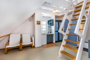 ブコビナ・タトシャンスカにあるWilla Marysin Bukowina Tatrzańskaの階段と椅子2脚、キッチンが備わる客室です。