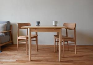 a wooden table with two chairs and a table with two cups on it at mizuki natural villa in Higashikawa