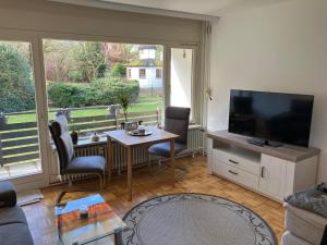 a living room with a television and a table and chairs at 1 - Zimmer Appartement - kleine Harzperle in Langelsheim