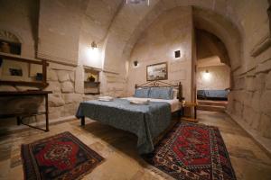 1 dormitorio con 1 cama en una habitación de piedra en Emit Cave Hotel, en Göreme