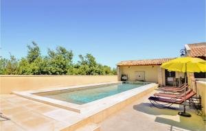 una piscina con 2 sillas y una sombrilla en 6 Bedroom Beautiful Home In Vallabregues, en Vallabrègues