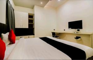 a bedroom with a bed and a desk with a television at Hotel Nikhil Regency in Bhilai