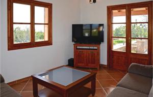 a living room with a tv and a coffee table at Beautiful Home In Santa Maria With Private Swimming Pool, Outdoor Swimming Pool And Swimming Pool in Santa Maria del Camí