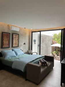 a bedroom with a large bed and a couch at DJipangan Home in Bantul