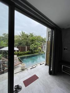 a view of a swimming pool through a sliding glass door at DJipangan Home in Bantul