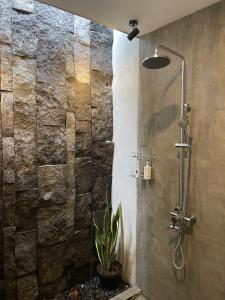a shower stall with a plant in a bathroom at DJipangan Home in Bantul
