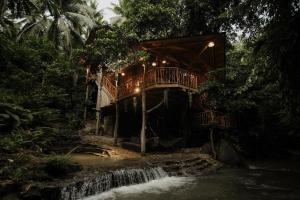 a tree house with a bridge over a waterfall at Treehouse de Valentine in Balamban
