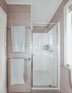 uma casa de banho com um chuveiro e uma porta de vidro em Ocean Blue em Peterborough