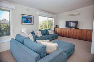 uma sala de estar com 2 sofás azuis e uma televisão de ecrã plano em Ocean Blue em Peterborough
