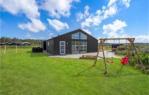 una casa negra con parque infantil en un patio en Amazing Home In Lkken With Wifi, en Løkken