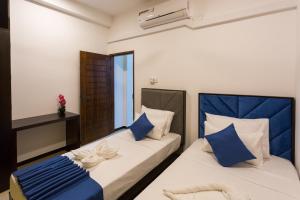- 2 lits avec des oreillers bleus dans une chambre dans l'établissement Niwahas Apartments Kottawa, à Pannipitiya