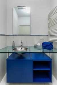 y baño con lavabo azul y espejo. en Villa Amalfi en Casalecchio di Reno