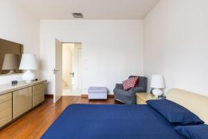 1 dormitorio con 1 cama azul y 1 sofá en Villa Amalfi, en Casalecchio di Reno