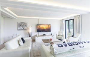 a white living room with white furniture and a flat screen tv at Captn in Binz