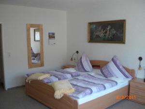 a bedroom with a large bed with purple pillows at Haus Hubertus in Winterberg