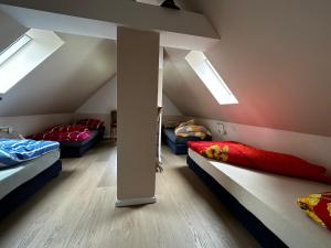a attic room with two beds and skylights at Bahnhof Paulinzella mit Sauna in Königsee